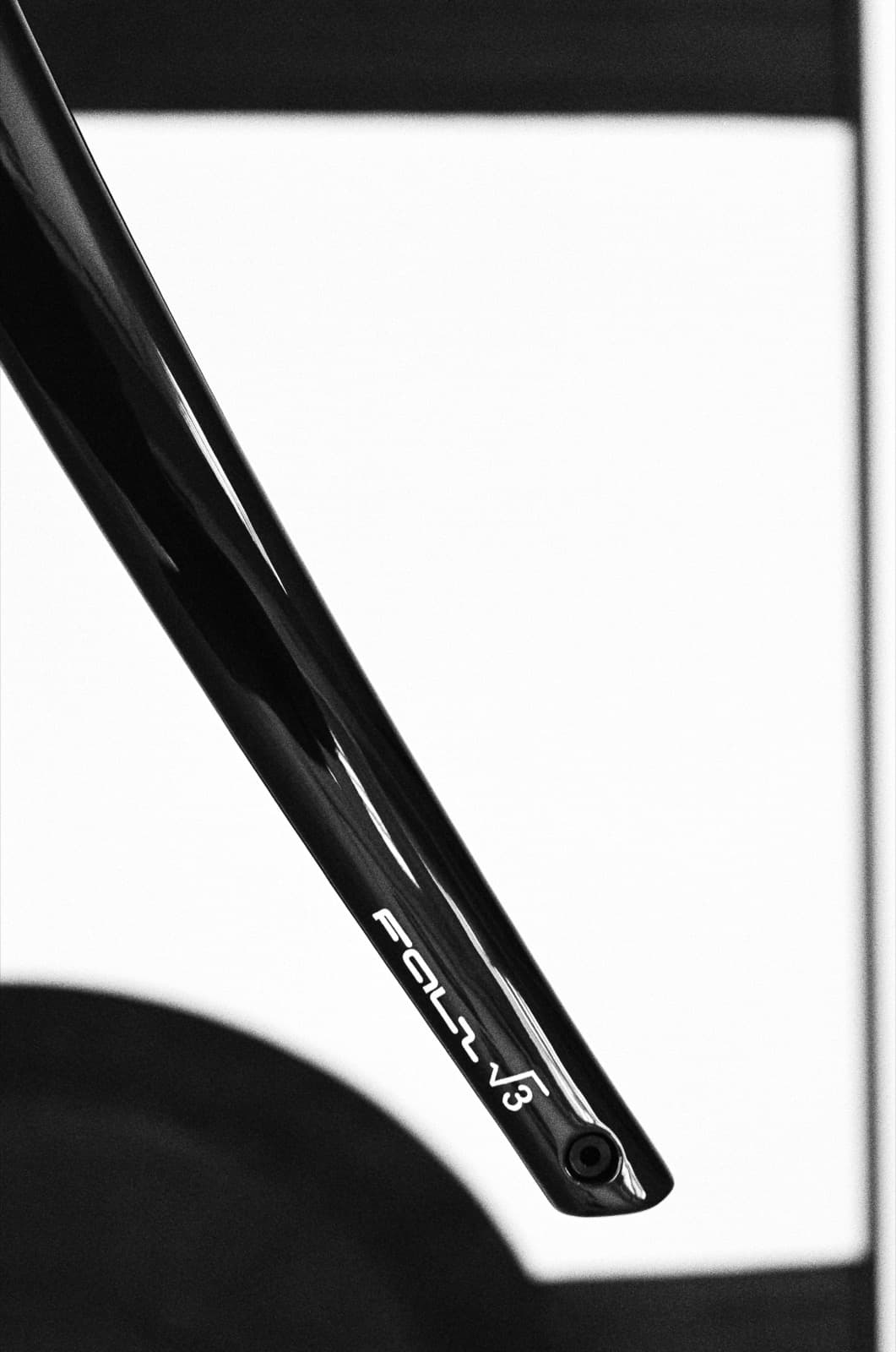 Close-up detail of a black FOLL √3 carbon fork showing the etched branding